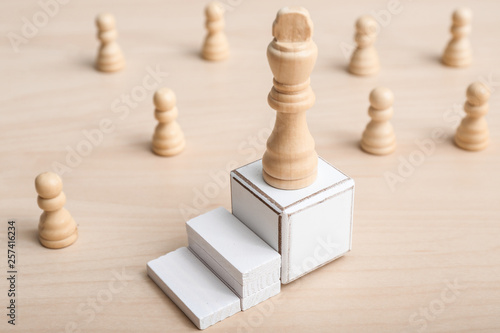 Cube with chess piece on table. Concept of career growth