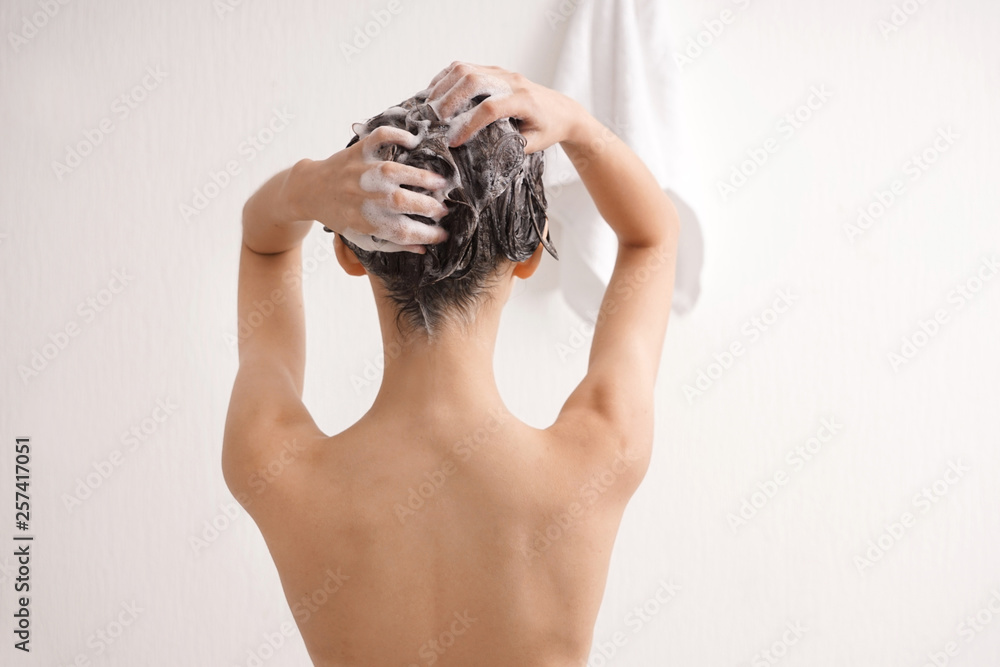 Fototapeta premium Young woman washing hair in bathroom