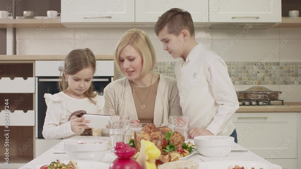Mom Communicates With Her Children At The Table During A Family Dinner Mom Communicates With Her Children At The Table During A Family Dinner