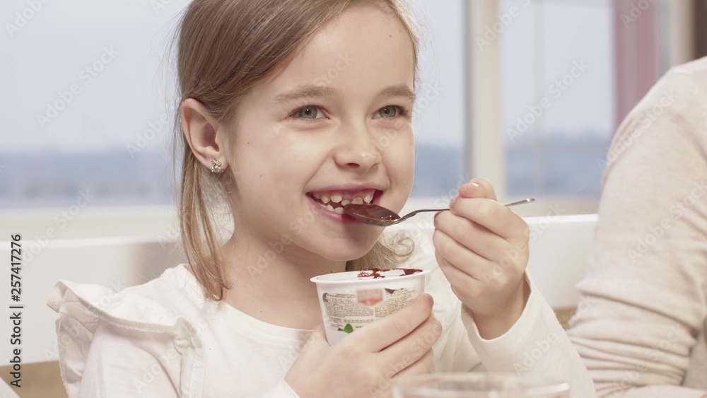 Little Girl Eats A Delicious Chocolate Mousse During A Family Dinner Little Girl Eats A Delicious Chocolate Mousse During A Family Dinner