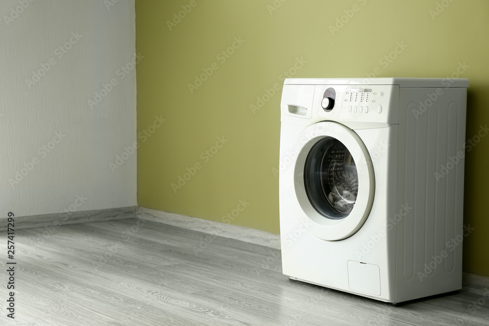 Modern washing machine near color wall Modern washing machine near color wall