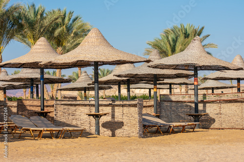 Wicker sun parasols and sun beds on the beach