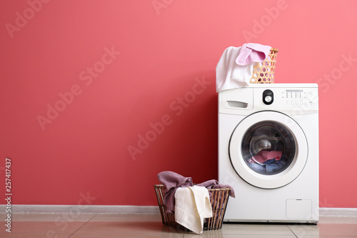 Modern washing machine and laundry near color wall