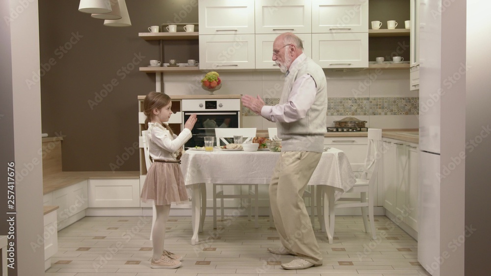 Little Girl With Her Grandfather Have Fun And Dancing Little Girl With Her Grandfather Have Fun And Dancing