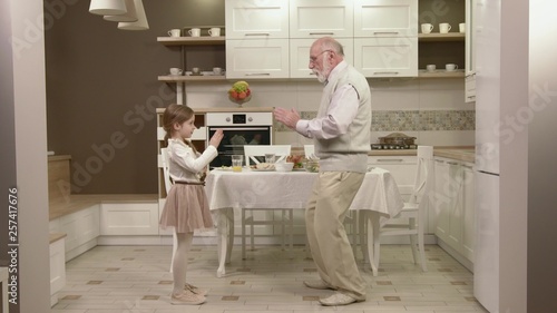 Little Girl With Her Grandfather Have Fun And Dancing