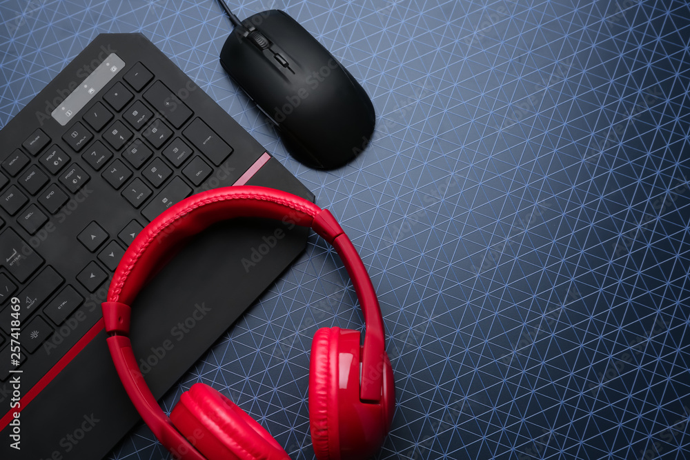 Modern gaming keyboard, mouse and headphones on table Modern gaming keyboard, mouse and headphones on table