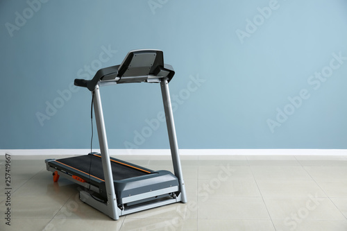 Fotografie Modern treadmill near color wall in gym