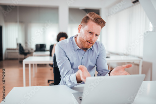 Annoyed business man looking at laptop screen. © bnenin