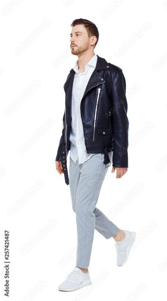 Front view of going handsome man in a leather jacket and trousers. Front view of going handsome man in a leather jacket and trousers.