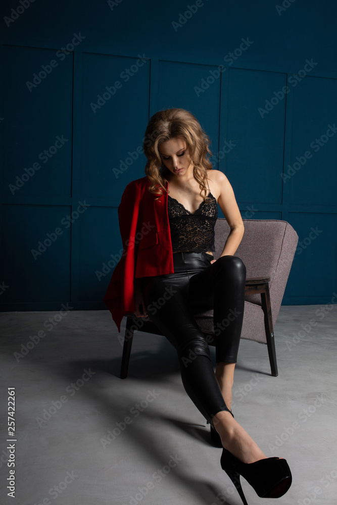 Fashion shoot of glam blonde woman wearing trendy outfit, posing at studio