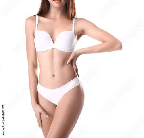 Beautiful young woman in underwear on white background