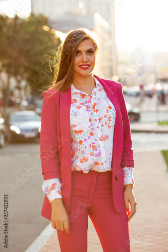 Elegant brunette girl wearing costume and blouse posing with soft evening sunlight © vpavlyuk