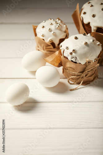 traditional easter cakes with chicken eggs on white wooden surface