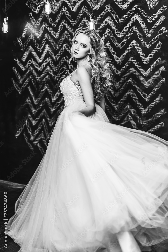 Fototapeta premium Close up black and white portrait of elegant fashionable beautiful bride with curly hairstyle indoors. Wedding, glamour, black and white photo concept