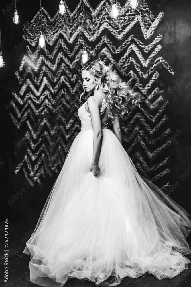 Close up black and white portrait of elegant fashionable beautiful bride with curly hairstyle indoors. Wedding, glamour, black and white photo concept