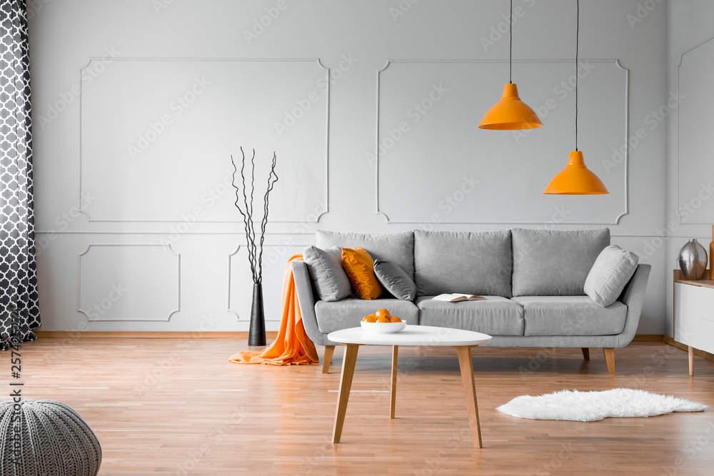 Copy space on empty grey wall of elegant orange and grey living room interior - obrazy, fototapety, plakaty 