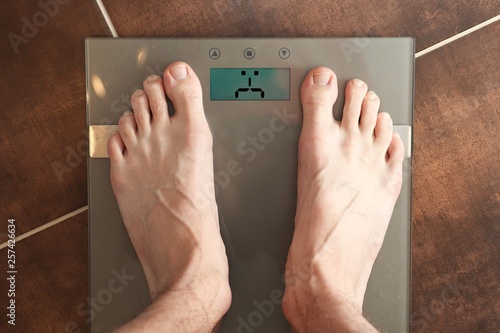 Standing on the weight scale. Overweight / underweight. Sad emoticon version