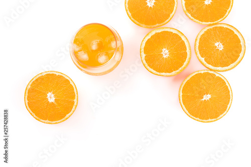 A glass of fresh orange juice with orange halves  shot from the top on a white background with copy space