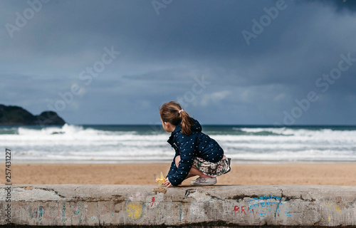 Niña observando las olas del mar