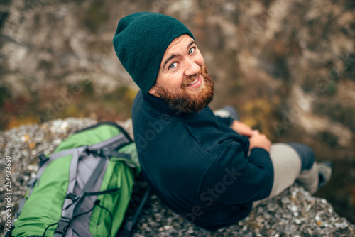 Bilde på lerret Outdoors rear view  portrait of happy hiker young man in green hat, feel good after hiking in mountains