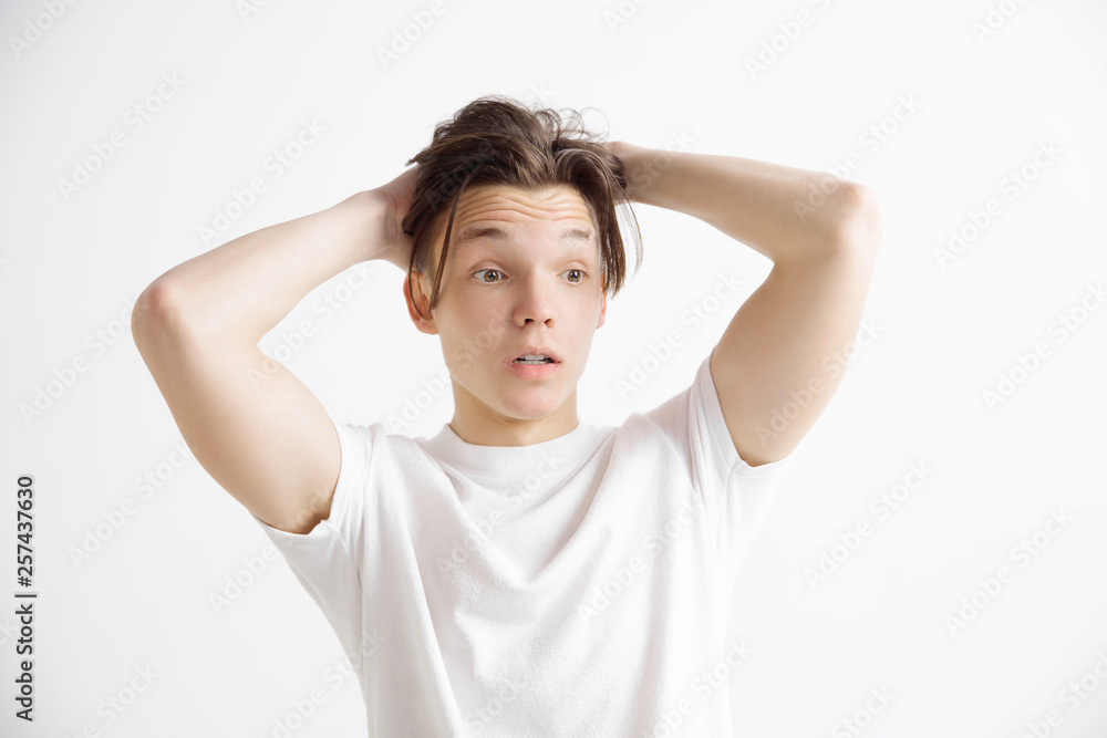 Wow. Attractive male half-length front portrait on gray studio backgroud. Young emotional surprised man standing with open mouth. Human emotions, facial expression concept Wow. Attractive male half-length front portrait on gray studio backgroud. Young emotional surprised man standing with open mouth. Human emotions, facial expression concept