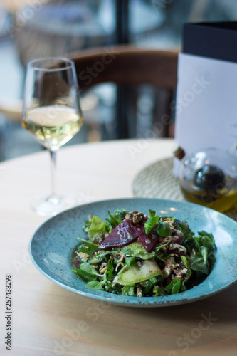Vegeterian salad on table with wine in restaurant