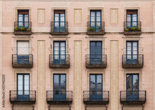 Windows and balconies in row on facade of historic building