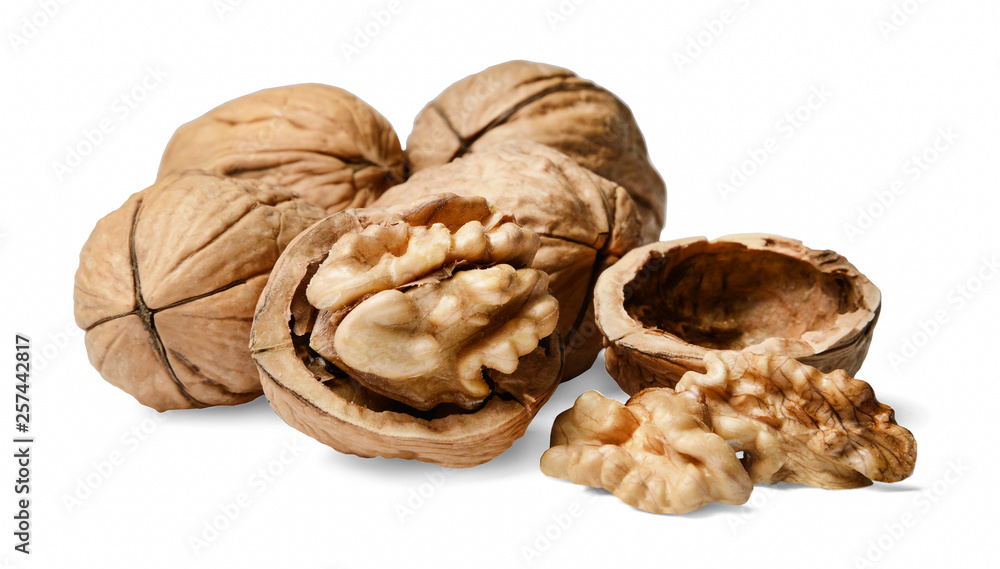 A bunch of whole and chopped walnuts. White isolated background. Side view. A bunch of whole and chopped walnuts. White isolated background. Side view.