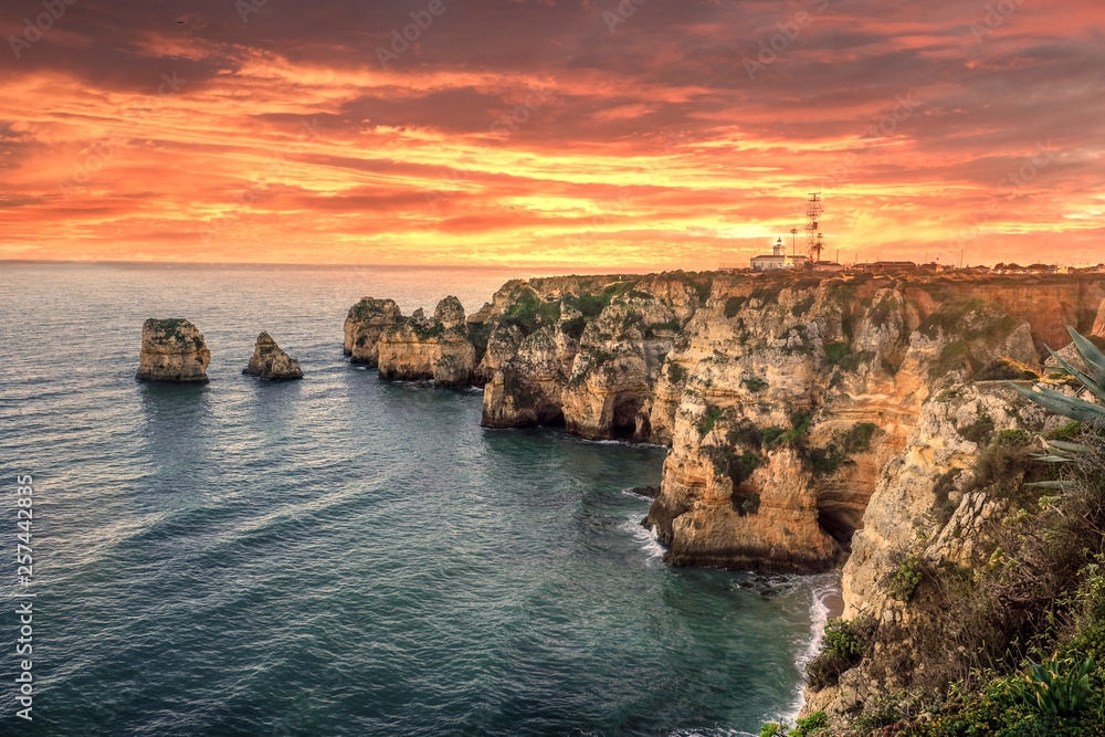 seascape. cliffs and lighthouse on the shores of the atlantic ocean at sunset in the vicinity of the city of lagos in portugal seascape. cliffs and lighthouse on the shores of the atlantic ocean at sunset in the vicinity of the city of lagos in portugal