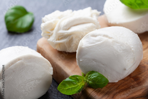 Mozzarella cheese with basil on wooden board. Natural italian dairy product. photo