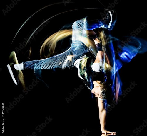 one chinese young man hip hop break dancer dancing isolated on black background with speed light painting effect motion blur