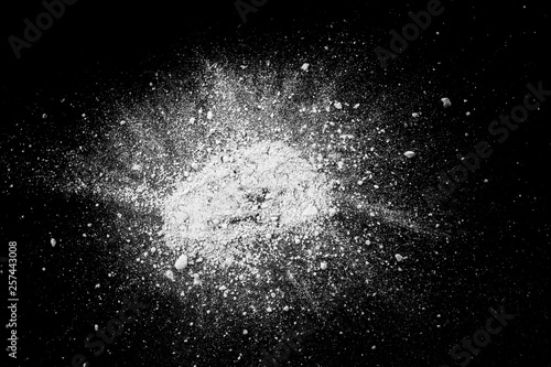 White powder explosion.Freeze motion of white dust particles on black background.