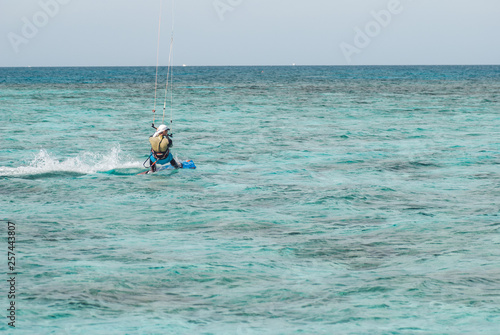 professional kiter glide the water surface of the ocean at great speed. Back view behind wide shot © skrotov