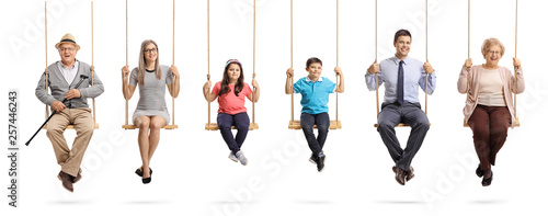 Grandparents, parents and children sitting on swings and smiling at the camera photo