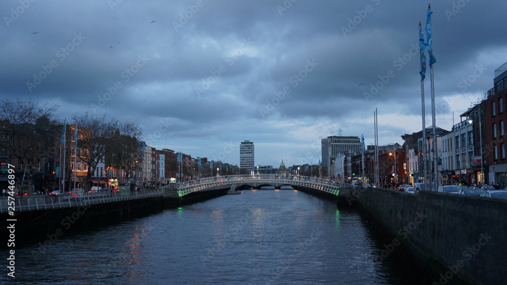 Naklejka premium Dublin, Ireland. Night view of famous illuminated Ha Penny Bridge in Dublin, Ireland