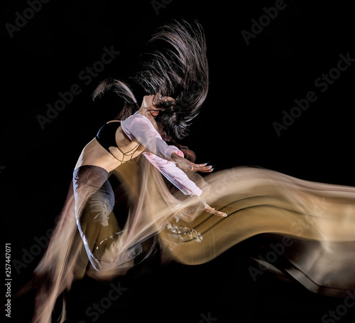 Fototapeta Naklejka Na Ścianę i Meble -  one caucasian young woman modern  dancer dancing isolated on black background with  light painting motion blur speed effect