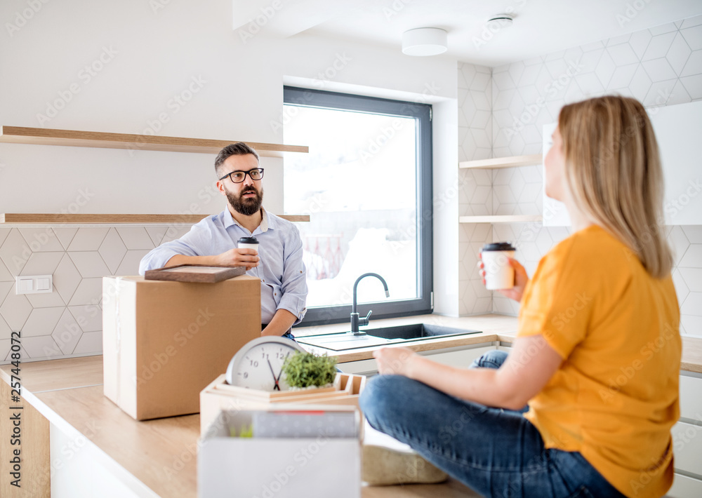 A young couple drinking coffee when moving in new home. A young couple drinking coffee when moving in new home.
