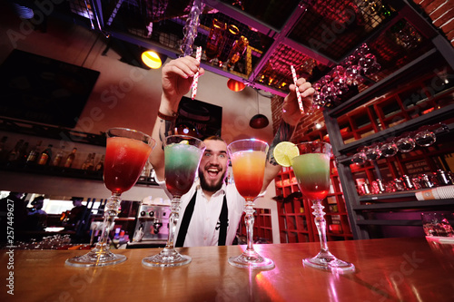 Canvas Print the bartender puts the tubes for cocktails in the prepared alcoholic drinks and