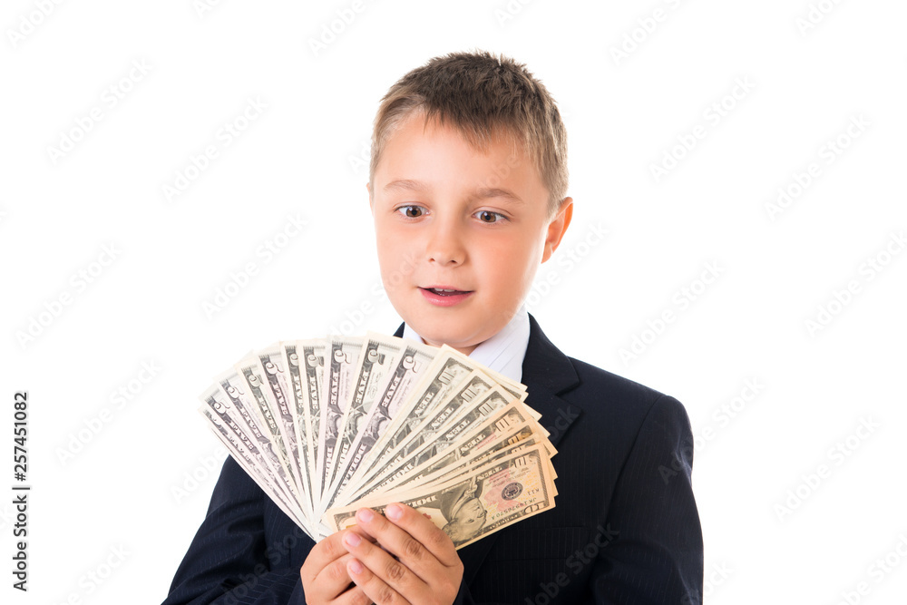 Young enterprising boy schoolboy in a business suit holding money in his hands. How to earn the first million dollars Young enterprising boy schoolboy in a business suit holding money in his hands. How to earn the first million dollars
