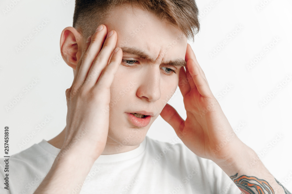 Man having headache. Business man standing with pain isolated on gray studio background. Male half-length portrait. Human emotions, facial expression concept Man having headache. Business man standing with pain isolated on gray studio background. Male half-length portrait. Human emotions, facial expression concept