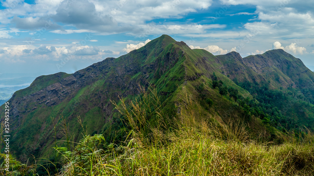 Mountain peak range landscape. Green mountain range view. Mountain peak blue sky white clouds panorama Mountain peak range landscape. Green mountain range view. Mountain peak blue sky white clouds panorama