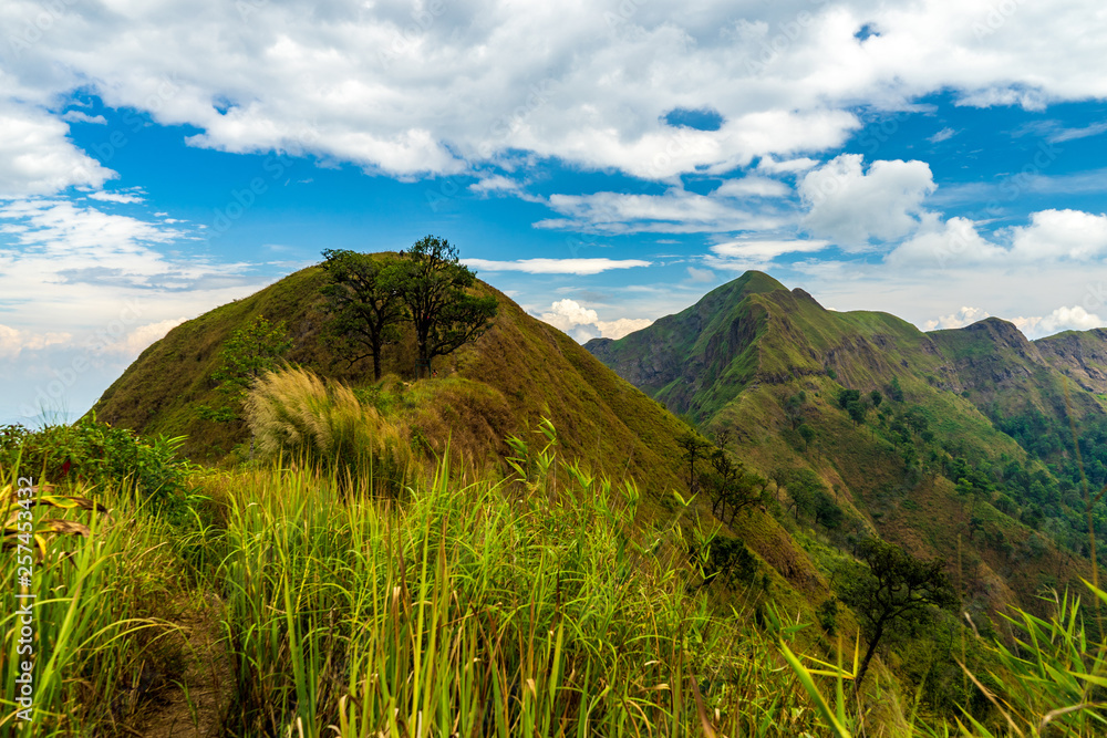 Mountain peak range landscape. Green mountain range view. Mountain peak blue sky white clouds panorama Mountain peak range landscape. Green mountain range view. Mountain peak blue sky white clouds panorama