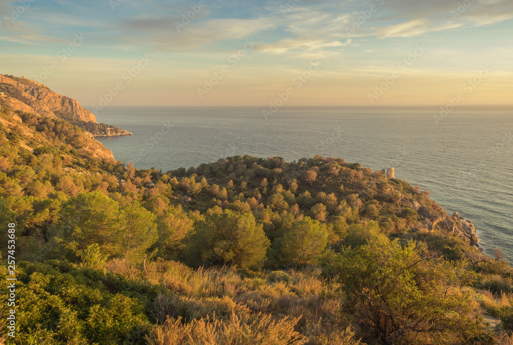 Motril, Granada, Andalusi, Spain - February 10, 2019: Sunset on the coast with the view of an old watchtower Motril, Granada, Andalusi, Spain - February 10, 2019: Sunset on the coast with the view of an old watchtower