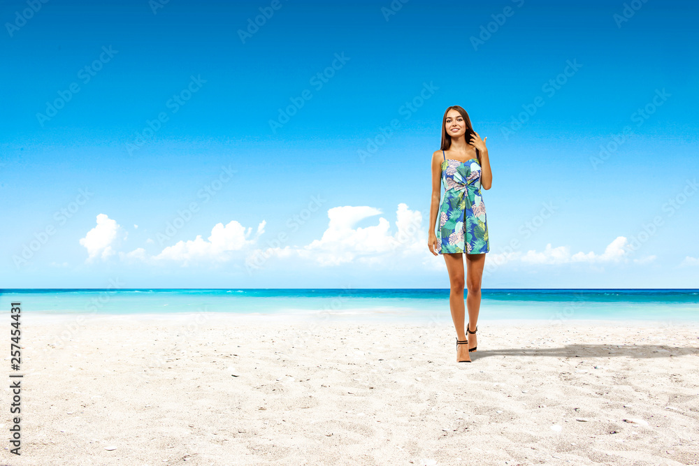Slim young woman on beach and sea landscape 