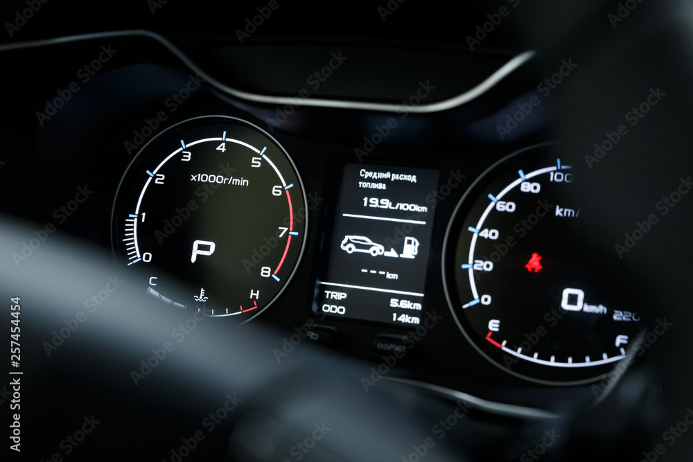 Close-up of a glowing beautiful dashboard of a modern expensive car. The interior of the car. The foreground is blurred