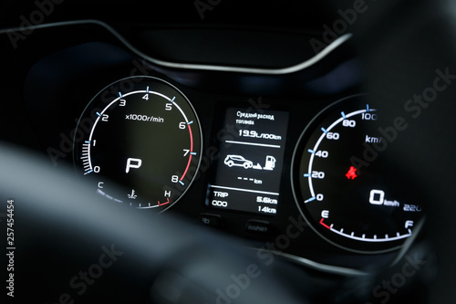 Close-up of a glowing beautiful dashboard of a modern expensive car. The interior of the car. The foreground is blurred