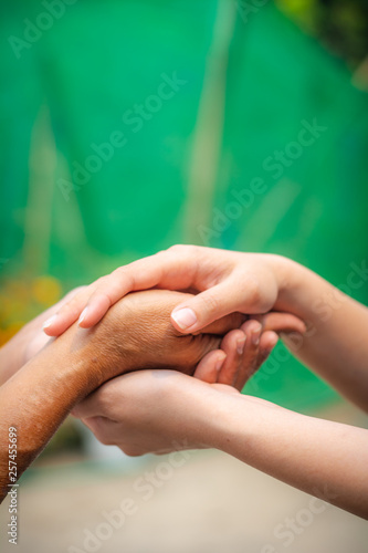 Asian senior and asian young holding hands.