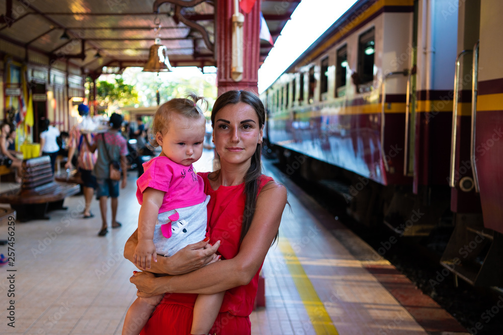 mother with baby is waiting for the train. Young mother travelling with baby by train.