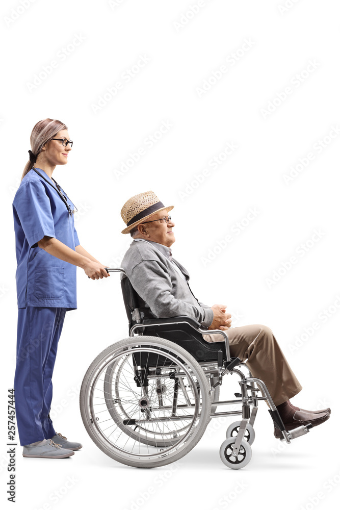 Young female nurse pushing an elderly gentleman in a wheelchair Young female nurse pushing an elderly gentleman in a wheelchair