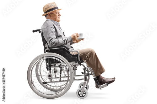 Elderly man sitting in a wheelchair with a cup of coffee